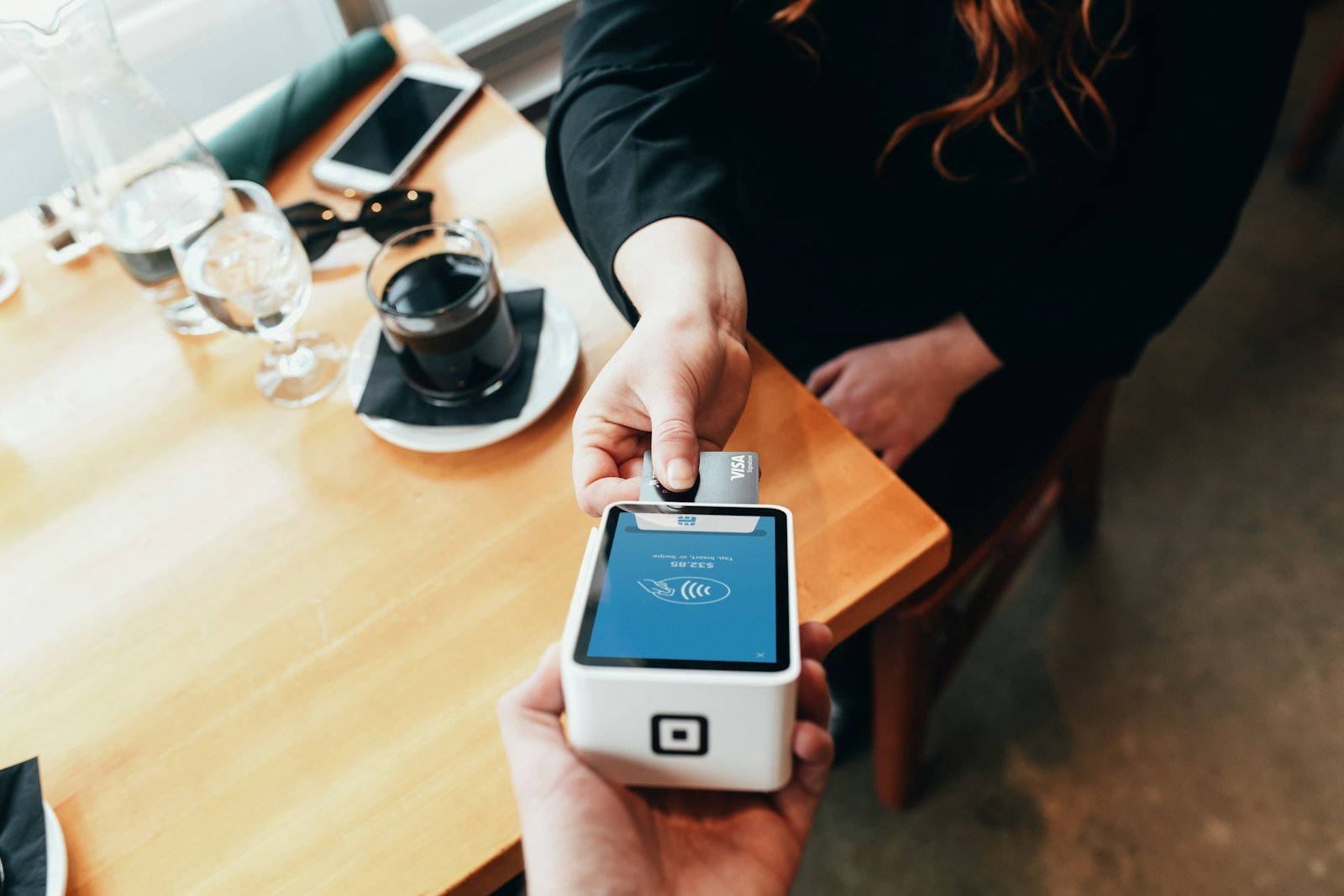 Person paying with a card at a payment terminal