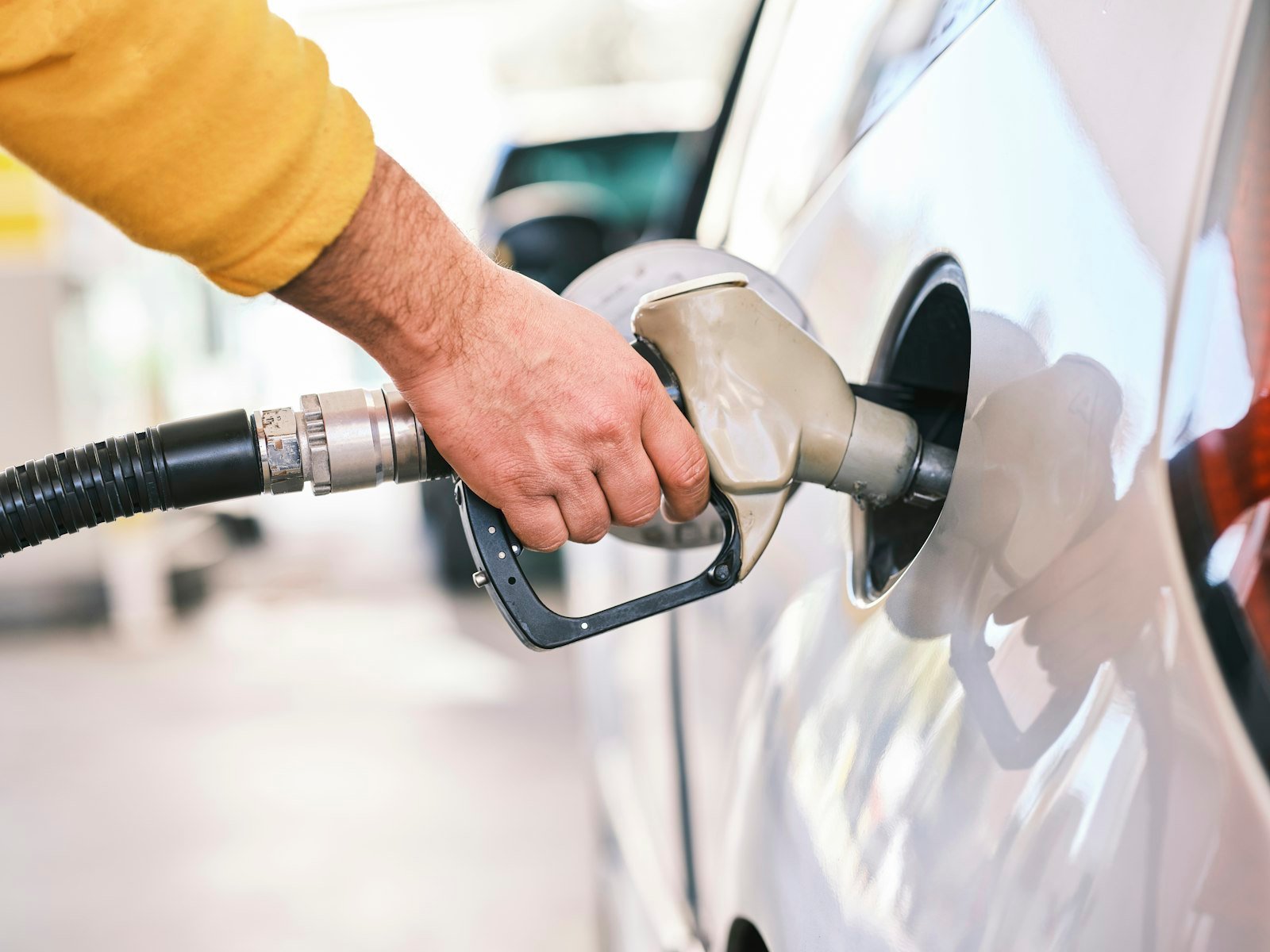Person filling a car at a fuel station